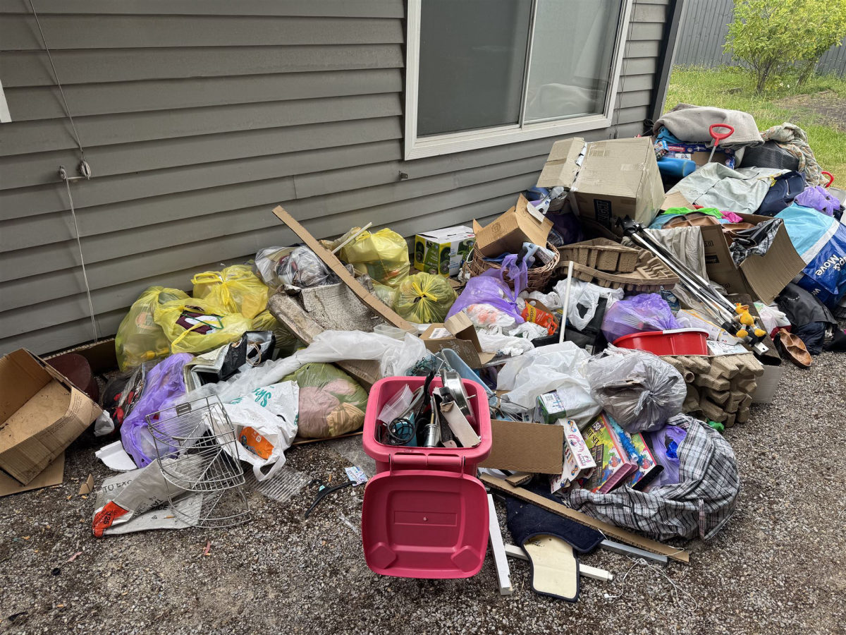 Large pile of bags and boxes beside house